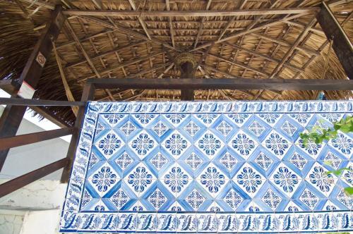 圣路易斯Pousada Maramazon的草屋顶上的蓝色和白色的瓷砖墙