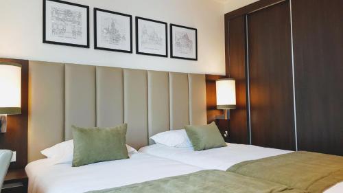 波尔图Porto City Hotel的两间相邻的床铺位于酒店客房内
