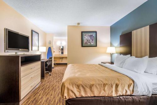 卡尔曼Quality Inn的配有一张床和一台平面电视的酒店客房