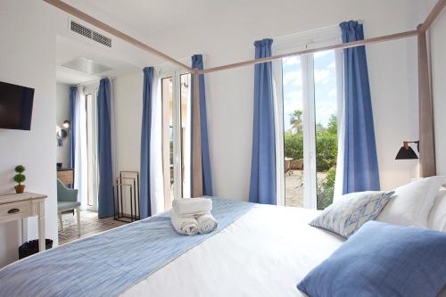 CalongeBoutique Hotel Petit Sant Miquel的一间卧室配有一张大床和毛巾