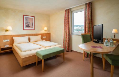 肖顿AKZENT Hotel Haus Sonnenberg的配有一张床和一张书桌的酒店客房