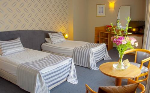 索非亚特里亚达酒店 的酒店客房,设有两张床和一张鲜花桌。