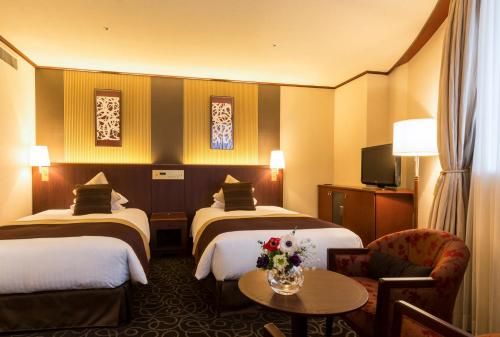 东京涩谷格雷斯登饭店的酒店客房设有两张床和一张桌子。