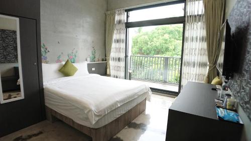 花莲市树の行旅(树的行旅)的一间卧室设有一张床和一个大窗户