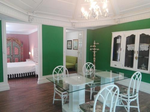 维拉·雷阿尔Casa da Varanda Verde的一间拥有绿色墙壁和桌椅的用餐室