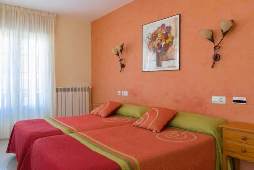 O Pindo阿里亚斯酒店的一间卧室配有橙色墙壁的床