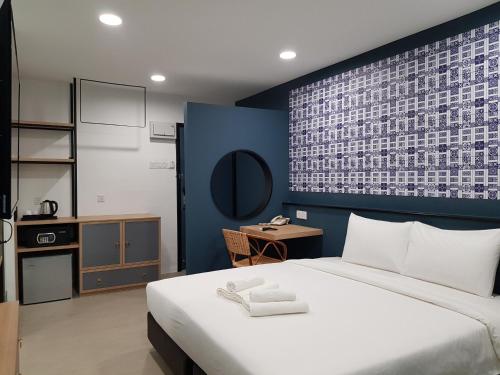 巴生Bloommaze Boutique Hotel Klang的一间卧室设有一张蓝色墙壁的大床