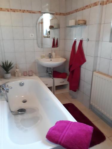 哈尔伯Ferienwohnung zum Schuster的浴室设有水槽和一个带紫色毛巾的浴缸。