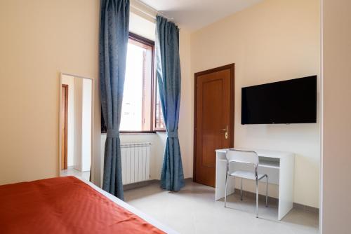 罗马Minerva Monks Inn的一间卧室配有一张床、一张书桌和一台电视