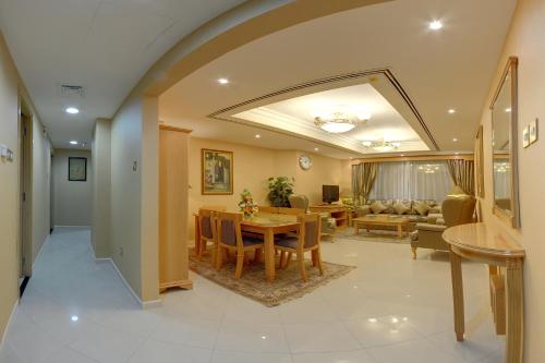 迪拜德尔拉套房豪华酒店的用餐室以及带桌椅的起居室。