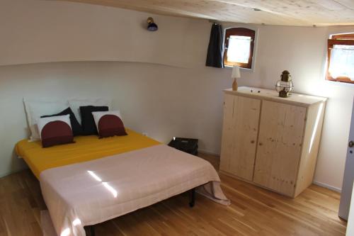 拉蒙维尔圣阿尼studio sur péniche La Tortue的一间卧室配有床、橱柜和窗户