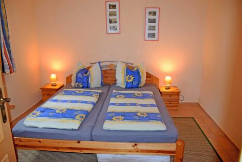 Sandortruhig gelegene Ferienwohnung am Ne的一间卧室配有两张带蓝色床单的床和两盏灯。