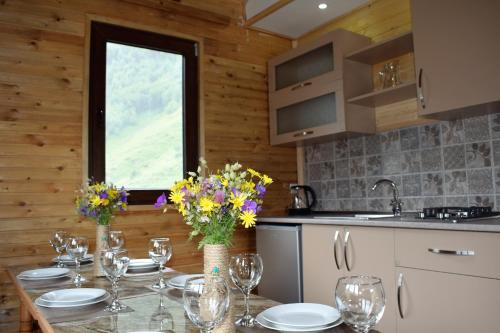 卡兹贝吉Gergeti Woods的厨房配有带玻璃杯和鲜花的桌子