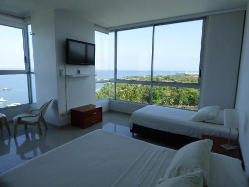 圣玛尔塔Costa Azul Suites 906的酒店客房设有两张床和电视。