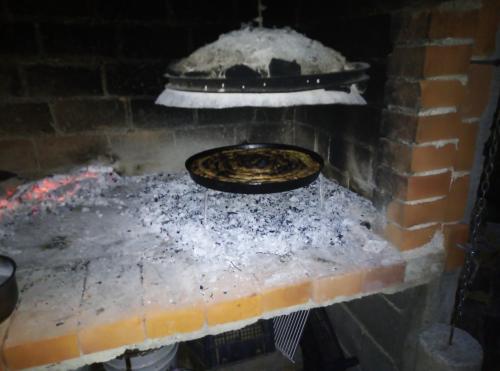 JablanicaVia Dinarica GuestHouse的砖炉里烹饪比萨饼