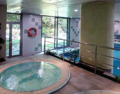 恩坎普纪莲酒店及Spa中心的一座大楼内带热水浴池的游泳池