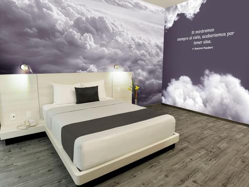 瓦哈卡市Life Hotel的卧室配有白色的床铺和云彩壁画