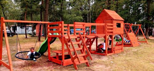 尼苏利采POLICYJNY OŚRODEK WYPOCZYNKOWY的一个带木游戏结构的儿童游乐场