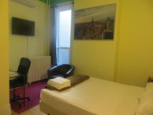 多伦多科普尼尔旅馆的一间卧室配有一张床、一张书桌和一个窗户。