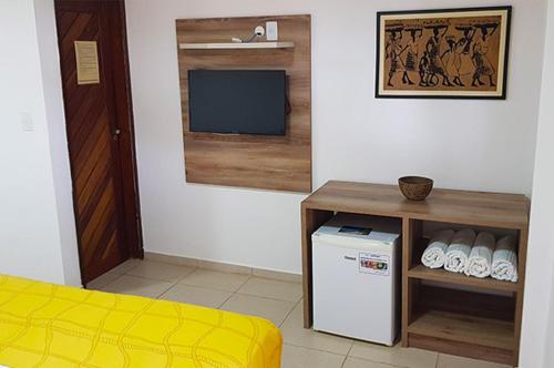 皮廷布Pousada Aconchego的客房设有小冰箱和电视。