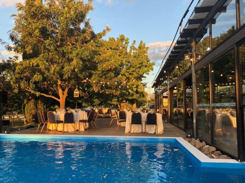 Termas de Salto Grande奥拉希奥基罗加酒店的一间带桌椅的餐厅和一个游泳池