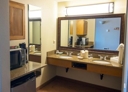 亚查茨Overleaf Lodge and Spa的一间带两个盥洗盆和大镜子的浴室