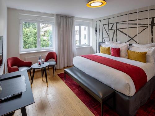 斯特拉斯堡Hôtel Garrigae Villa La Florangerie的酒店客房配有一张带红色和黄色枕头的大床