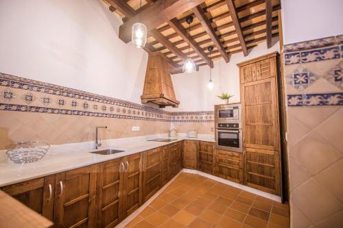 桑卢卡尔-德巴拉梅达Casa Boutique Sanlucar的厨房配有木制橱柜、水槽和炉灶。