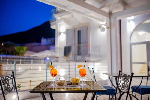 利帕里Odysseus Hotel的露台上的桌子上摆放着饮料和食物