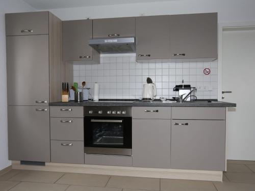 巴特贝林根Ferienwohnung Rheingeschaut的厨房配有白色橱柜和烤箱。