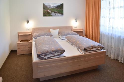 圣马蒂诺Ferienwohnungen Burgwies的一间卧室配有一张带两个枕头的床