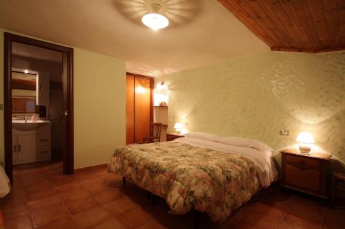 圣斯特凡诺·迪塞斯拉加德利塔酒店的一间带一张床铺的卧室,位于带天花板的房间内