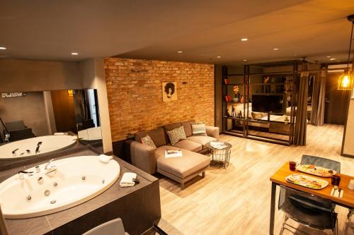 伊斯坦布尔161城市阁楼公寓的大型客厅设有浴缸和沙发。