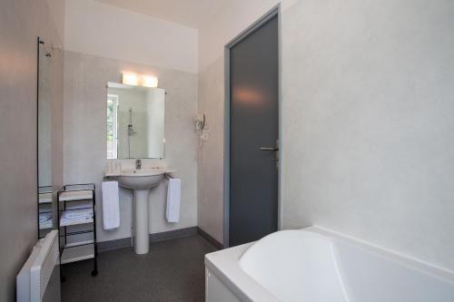 Manzac-sur-VernLe Lion d'Or的白色的浴室设有水槽和镜子