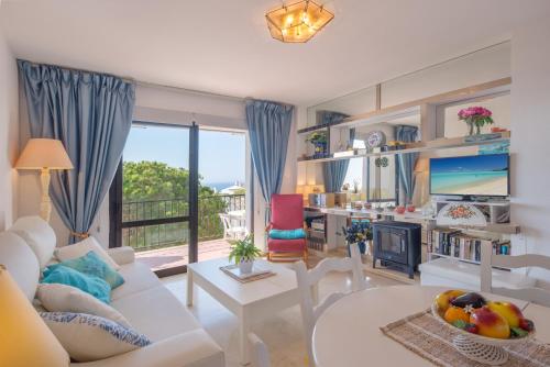 卡拉德米哈斯Beach Apartment Las Acacias Torrenueva的客厅配有白色沙发和壁炉