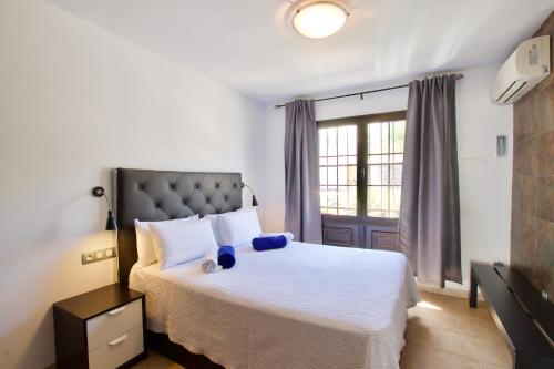 科斯塔特吉塞APARTMENT GOLDEN costa teguise的卧室配有一张大白色床和窗户