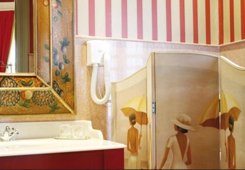 卡斯特罗波尔Hotel Palacete Peñalba的浴室内有两位客人的画作,配有遮阳伞