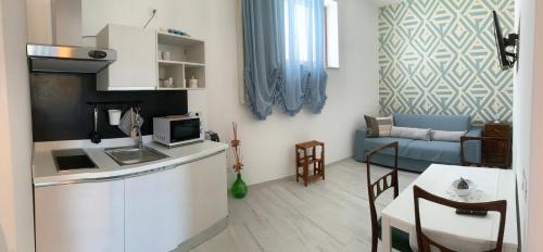 拉泰尔扎Il Belvedere, case vacanza的小厨房和带沙发的客厅