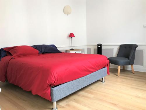 鲁昂Le secret de Léa的一间卧室配有红色的床和一张黑椅子