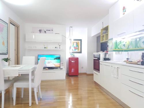 雅西White Dream Suites的白色的厨房配有桌子和红色冰箱