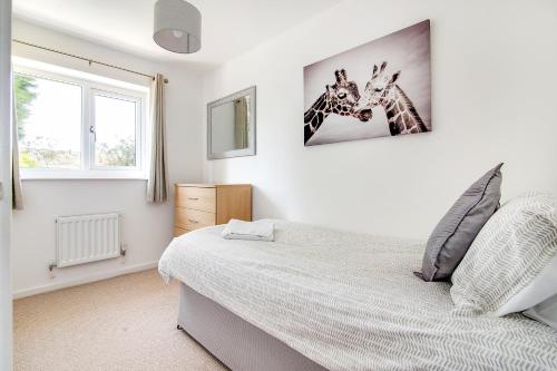 塔姆沃思Westmorland House的卧室配有一张床,墙上挂着两个长颈鹿