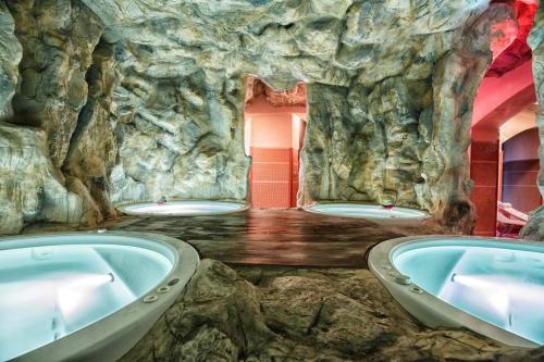 卢切拉维尼亚诺切利大酒店的石洞里带三个浴缸的浴室