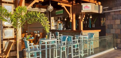 格兰贝伊Azure Beach Boutique Hotel的一间设有蓝色椅子的餐厅和一间酒吧