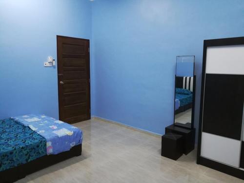 瓜拉丁加奴HOMESTAY DAMAI YUSMILA的蓝色的客房配有床和镜子
