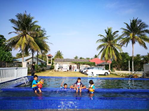 巴佐ALA Beach Lodge - Markisa Homestay的一群儿童在游泳池玩耍