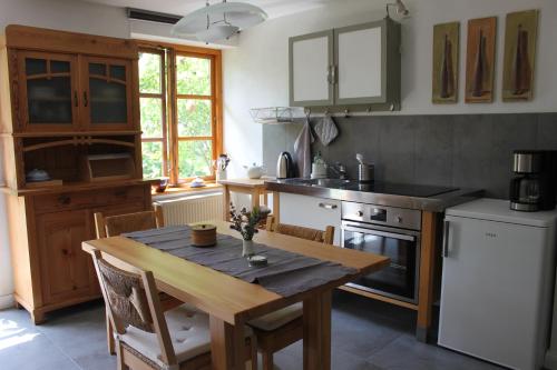 KluisKleine Auszeit的厨房配有木桌、炉灶和冰箱。