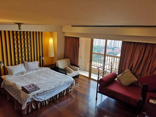 Kampong PenagaSunway Luxury Suites的一间卧室配有一张床和一张沙发,并设有一个阳台