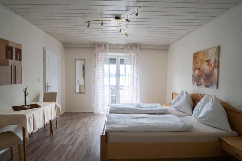 米尔施塔特Pension Pleikner的一间卧室设有两张床、一张桌子和一个窗口