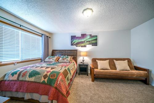 安克雷奇Polar Bear Den的卧室配有床、椅子和窗户。