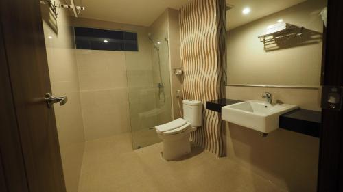 玛琅De Boutique Style Hotel的浴室配有卫生间、盥洗盆和淋浴。